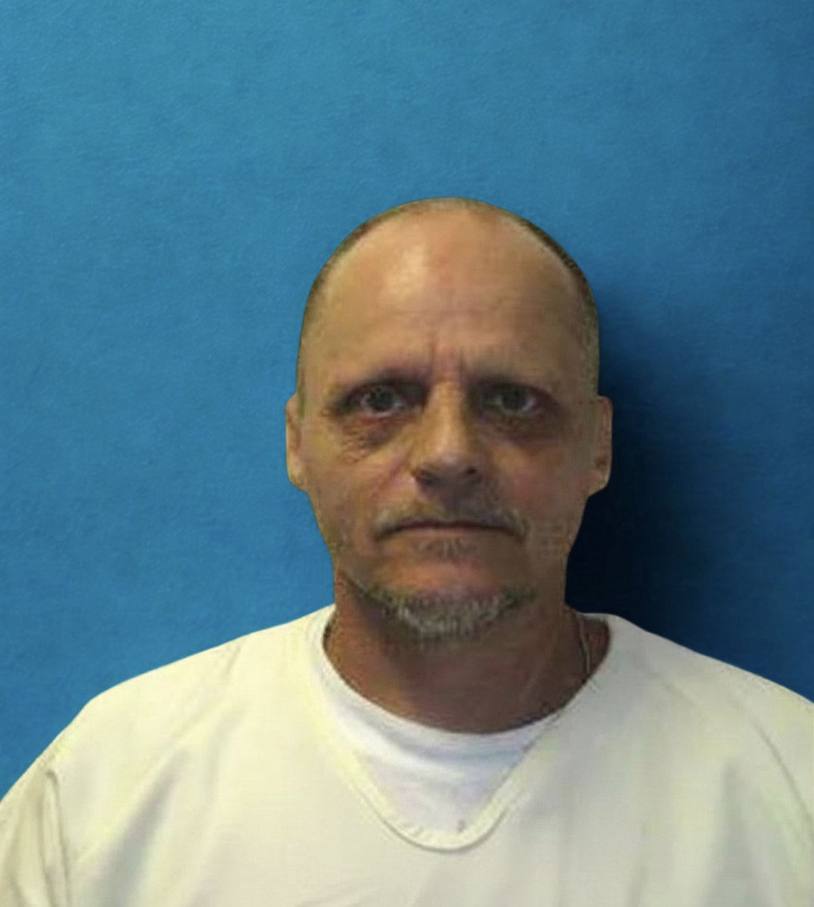 Photo of Darrell Hines, a caucasian man with short facial hair and very short, receding hair. He is wearing a yellow shirt and standing in front of a blue backdrop.
